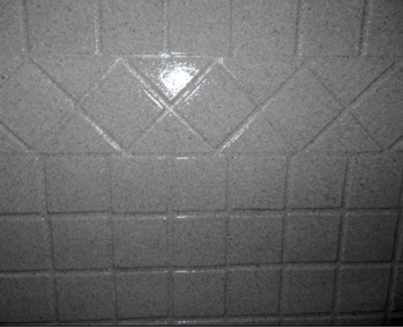 Close-up of white tiled wall, with a pattern of angled squares.