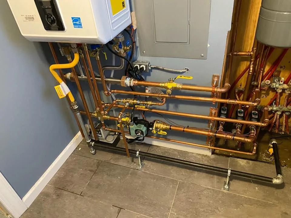 Utility room with wall-mounted boiler and exposed copper pipes over a tiled floor