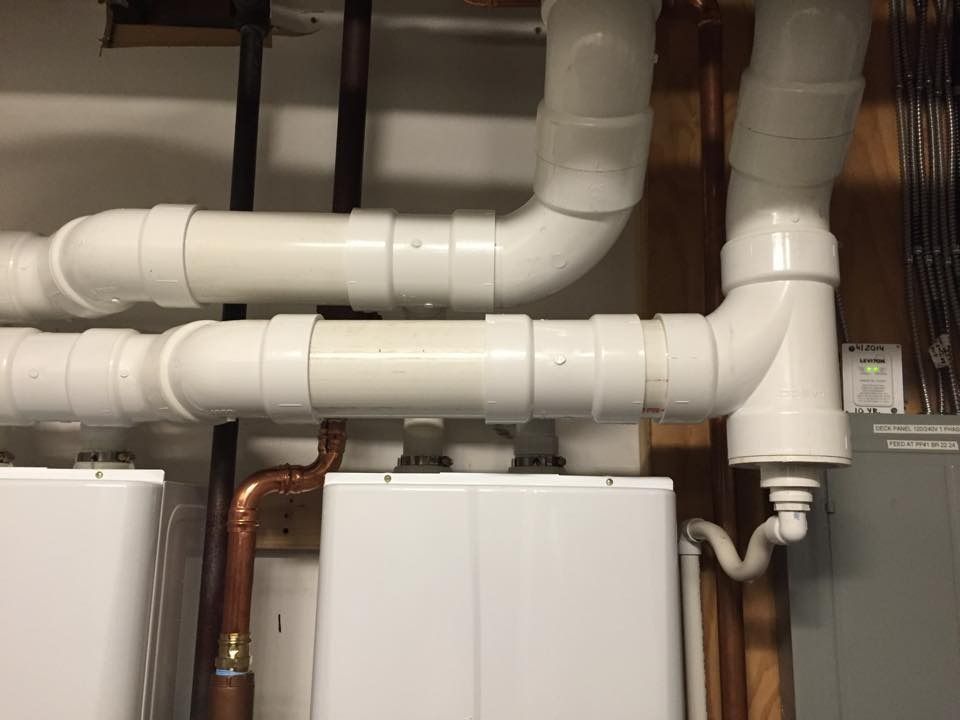 Basement utility room with white insulated pipes and water heaters.