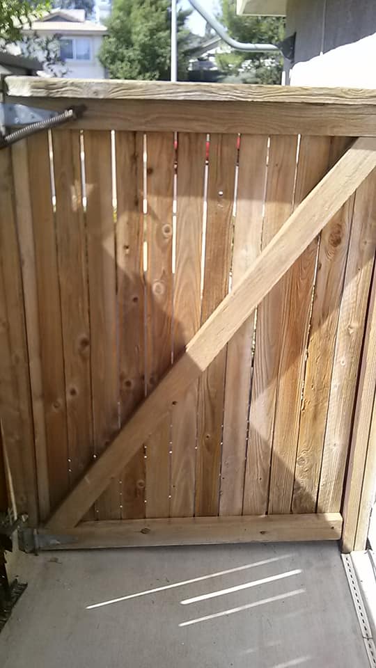 Wooden gate with diagonal brace; outdoor setting.
