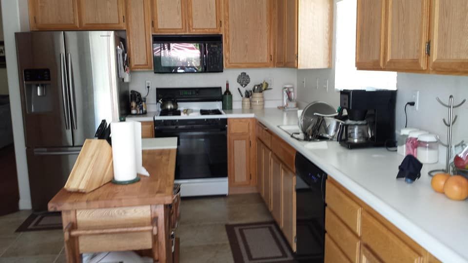 A kitchen with light wood cabinets, stainless steel fridge, and a countertop with a coffee maker.
