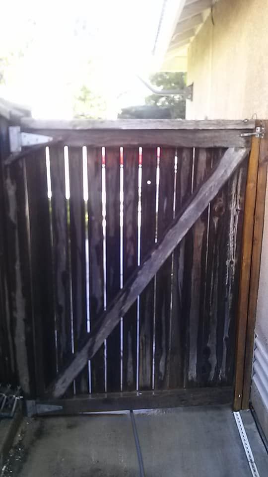 Wooden gate in a cement setting, with a diagonal support beam.