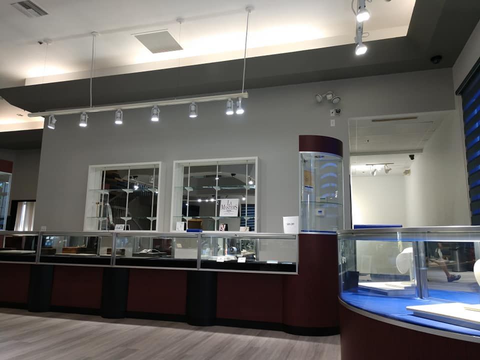Interior of a jewelry store with display cases, overhead lighting, and security cameras.