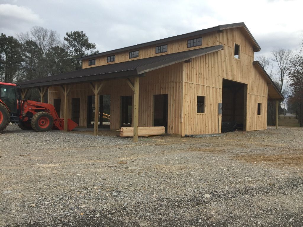 New wooden barn under construction; tractor parked nearby.