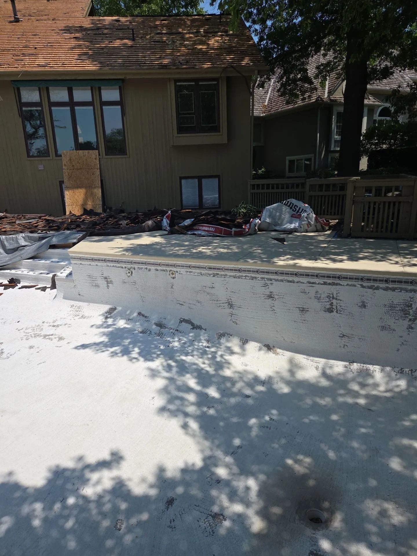 Backyard with partial house, deck, and concrete work in progress.