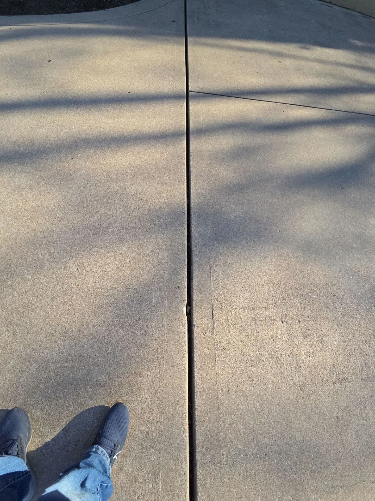 Feet on concrete, looking down at expansion joint.