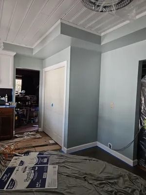 Interior room with freshly painted blue-green walls, white trim, and a white ceiling.