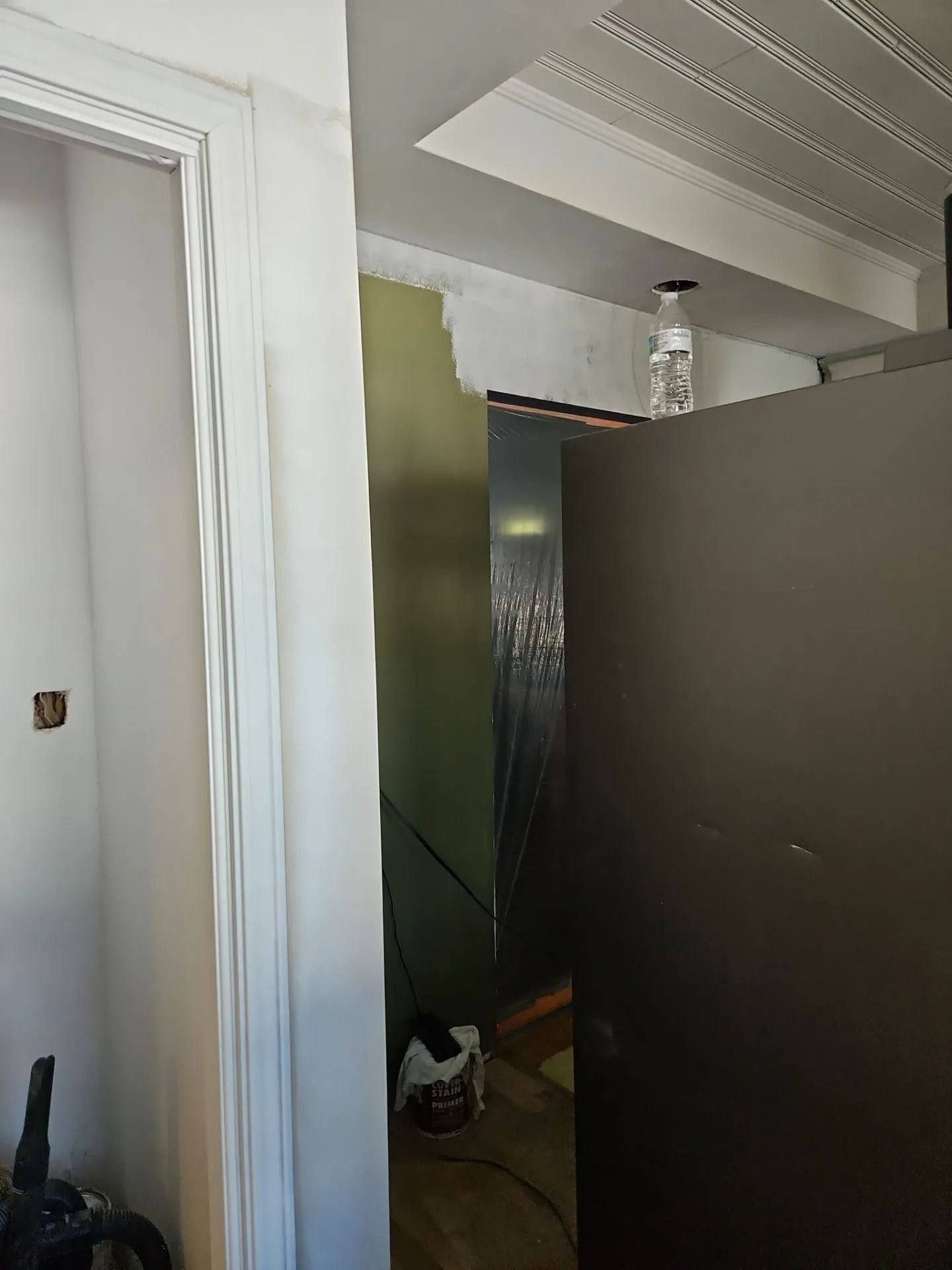 Construction site interior with exposed ductwork, door frame, and partially built wall.