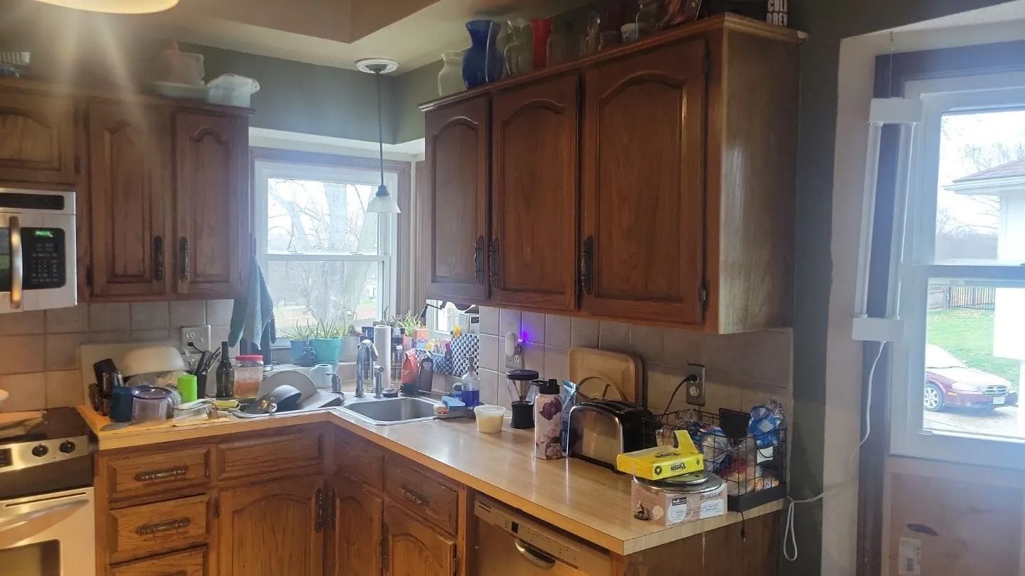 Kitchen with wooden cabinets, sink, and appliances. A window is visible.