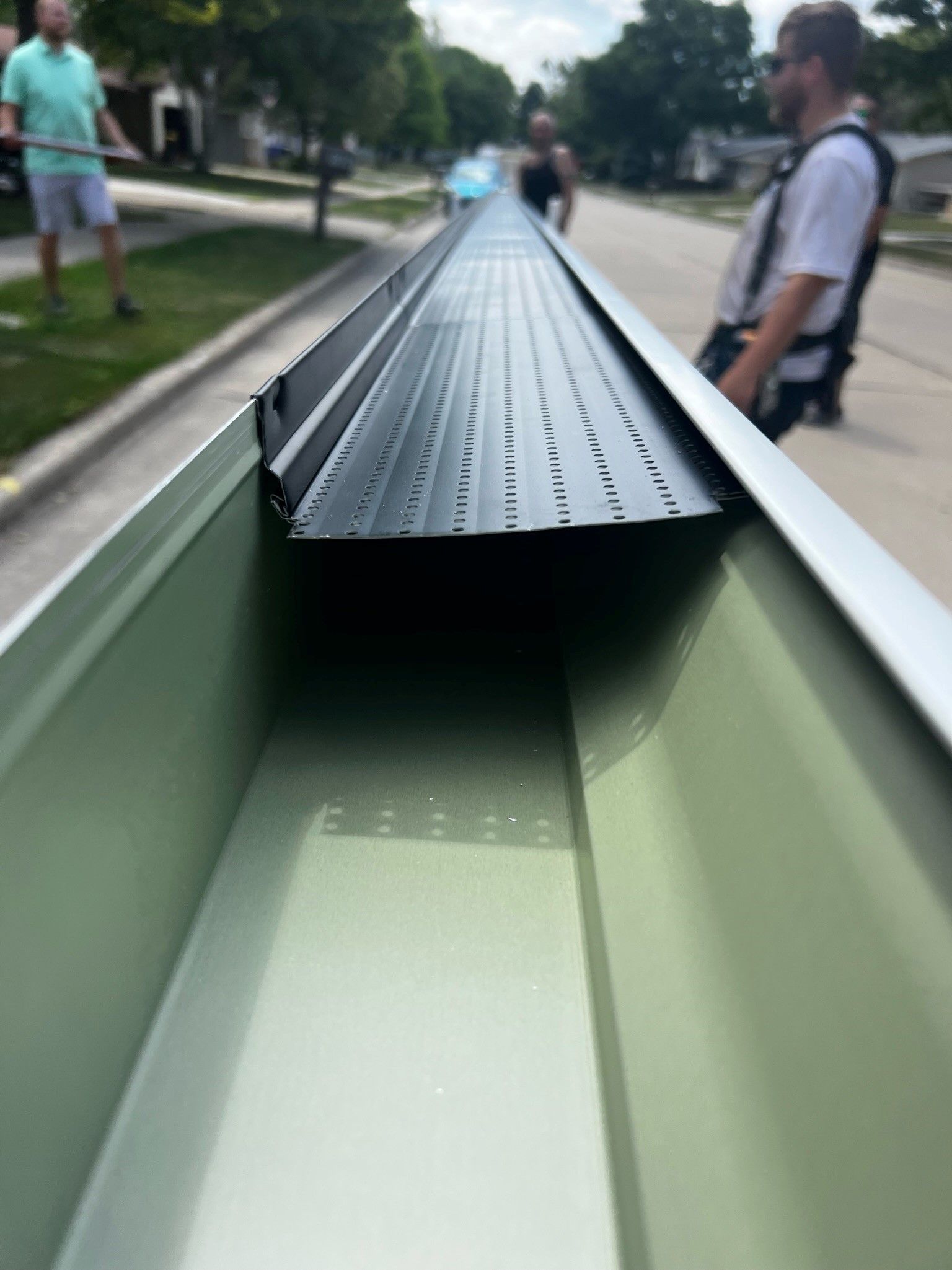 A man is standing next to a gutter that is very long