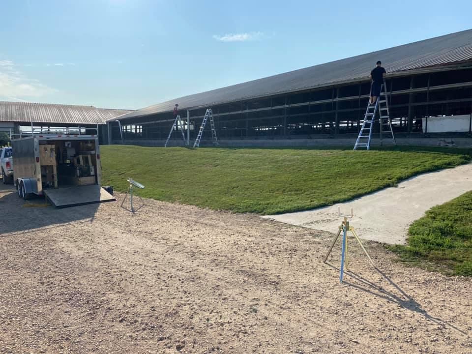 A man is standing on a ladder in front of a building.