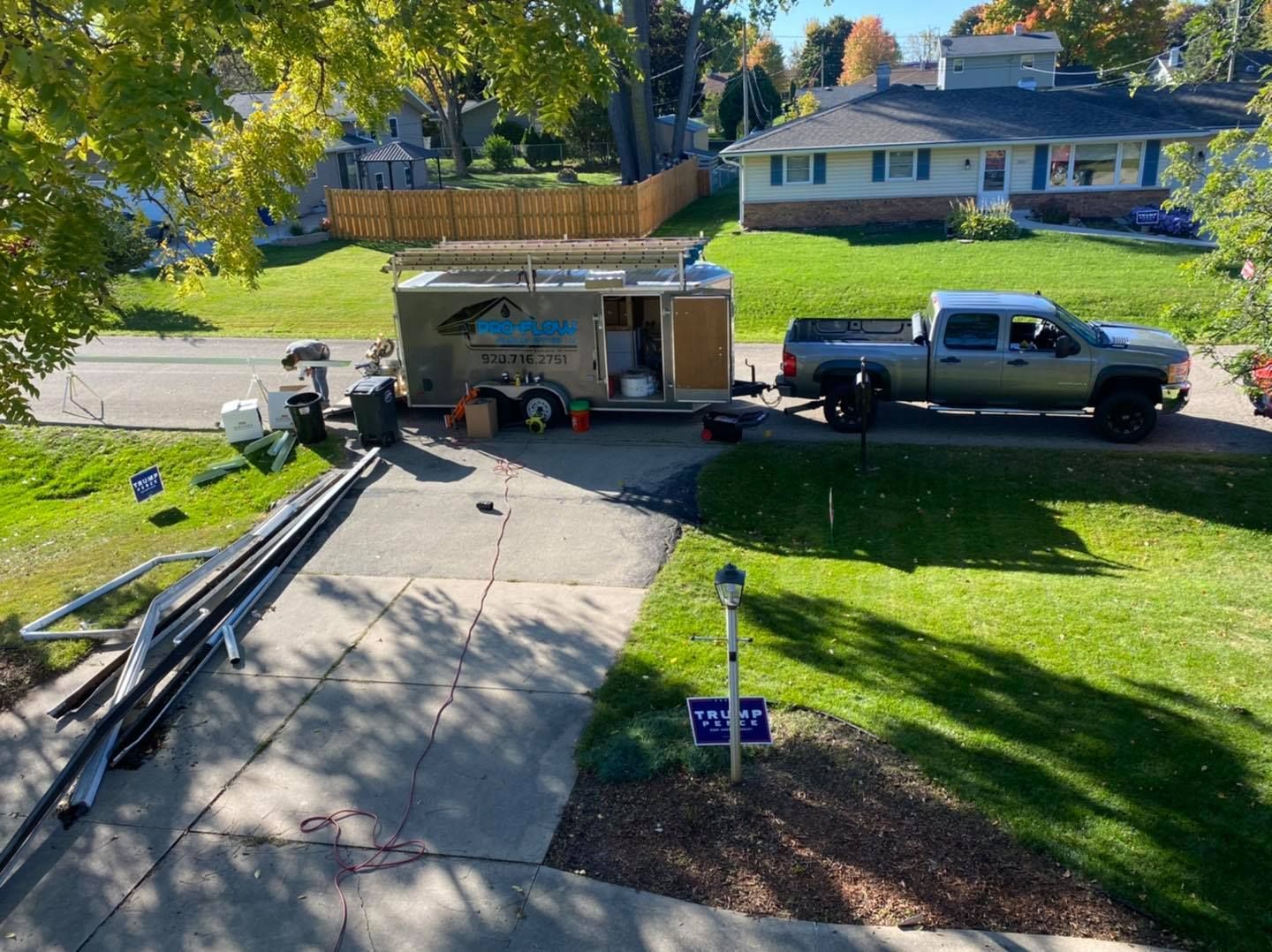 A truck is parked in a driveway next to a trailer.