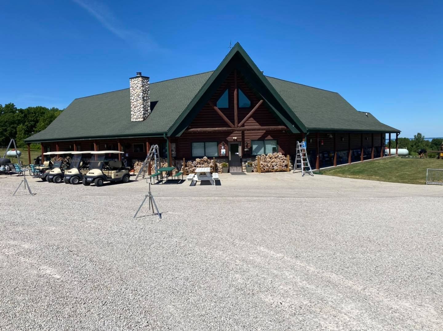 A large log cabin with golf carts parked in front of it