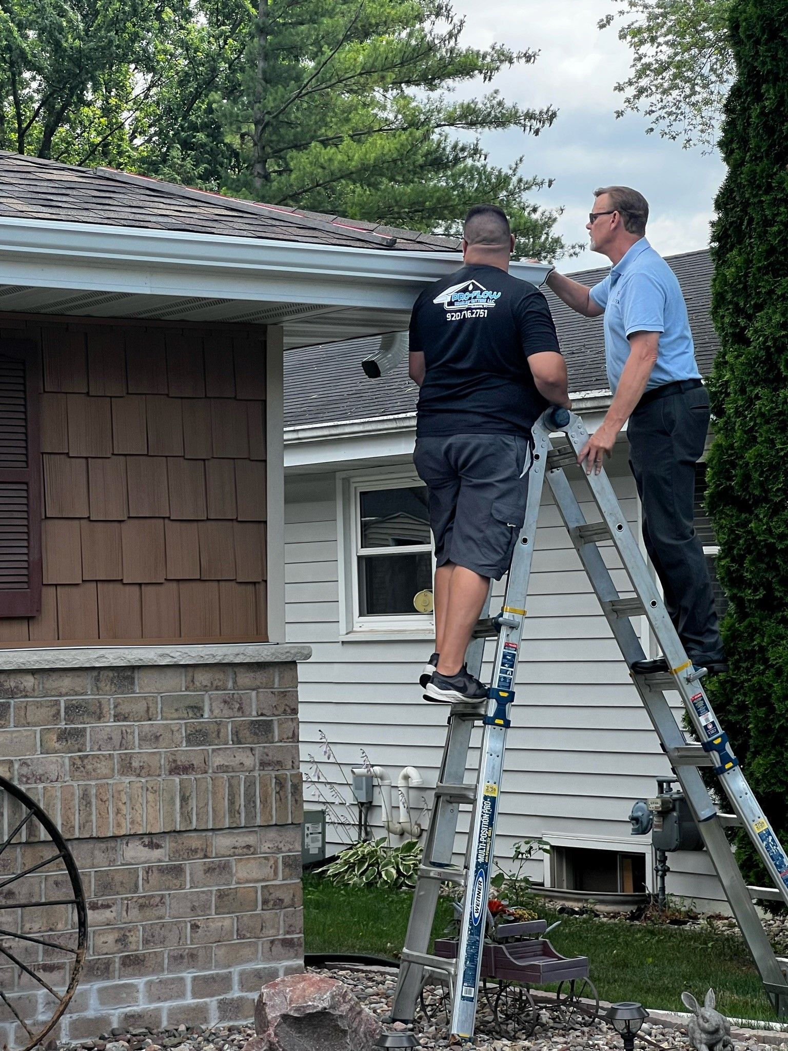 Two men are working on the roof of a house.