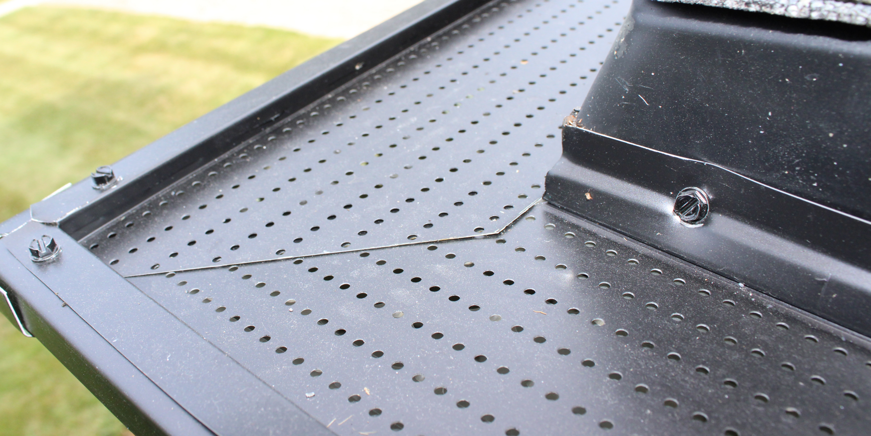 A close up of a metal tray with holes in it.