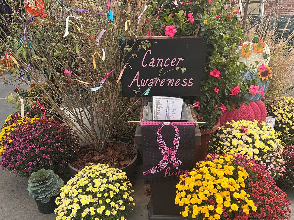 A display of flowers and a sign that says cancer awareness