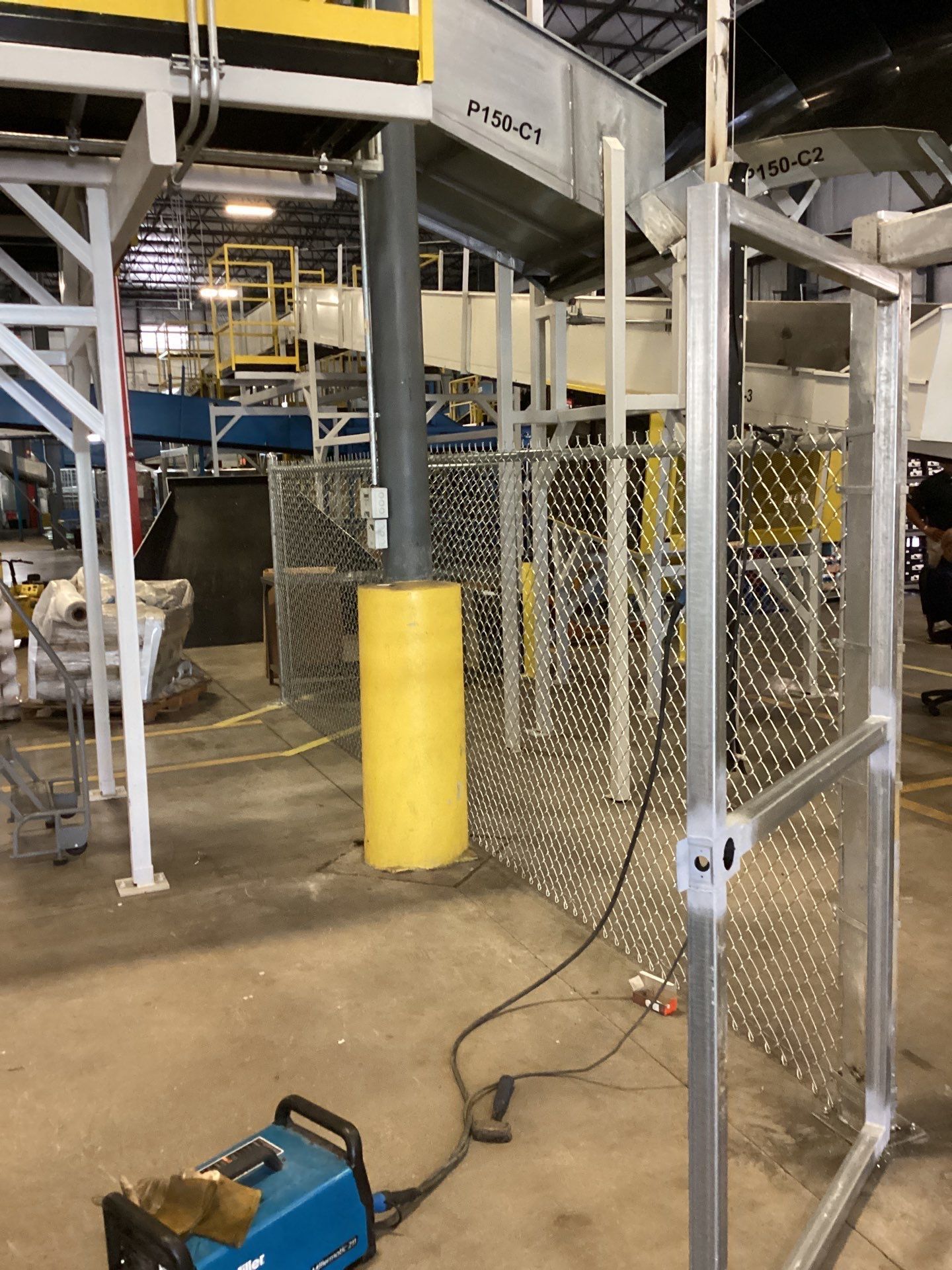 Welding machine and metal fencing in an industrial setting.