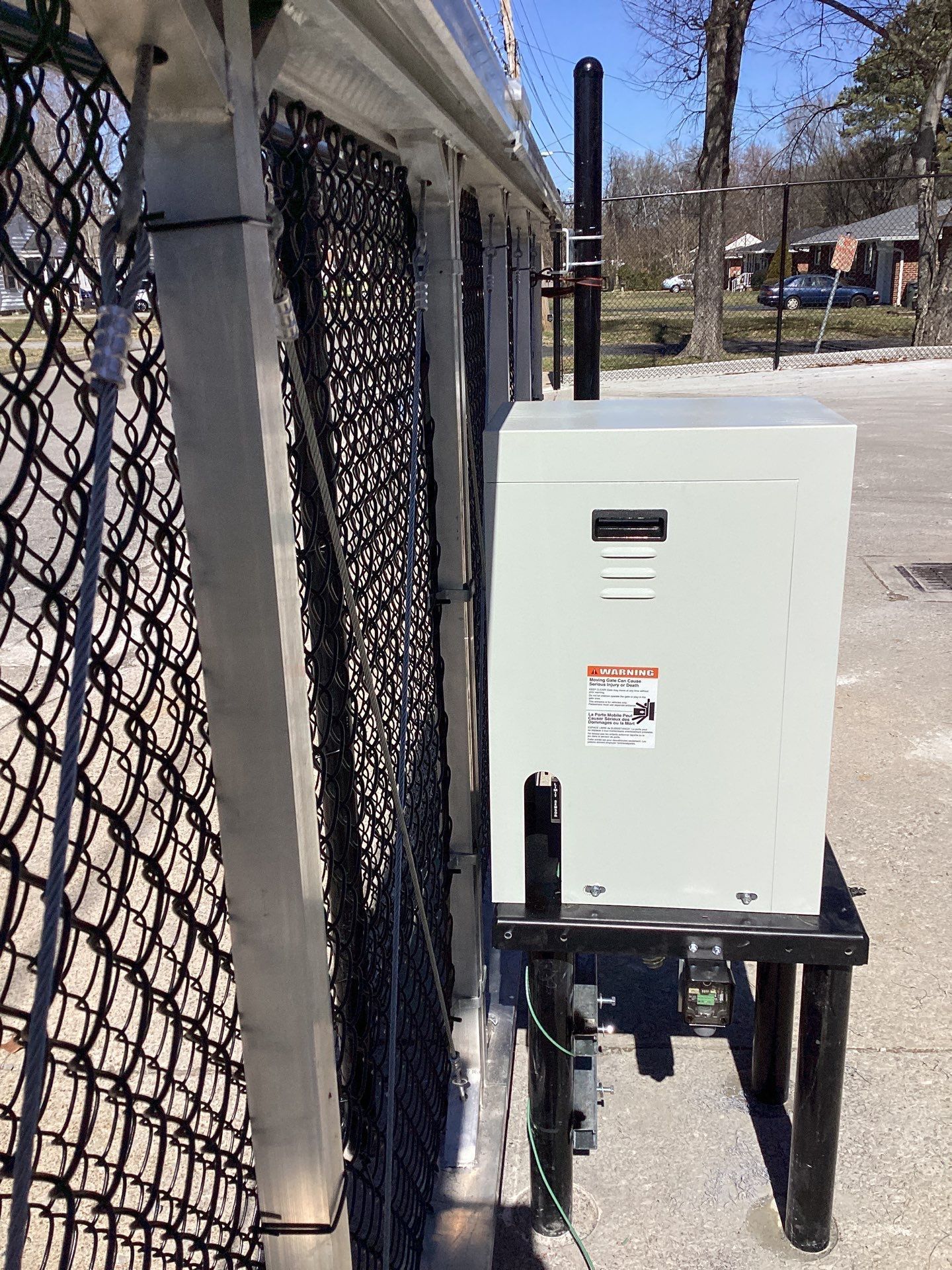 Metal gate with a control box and antenna attached.