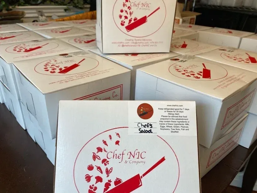 Boxes of food, "Chef Nic & Company" logo visible. White boxes stacked.
