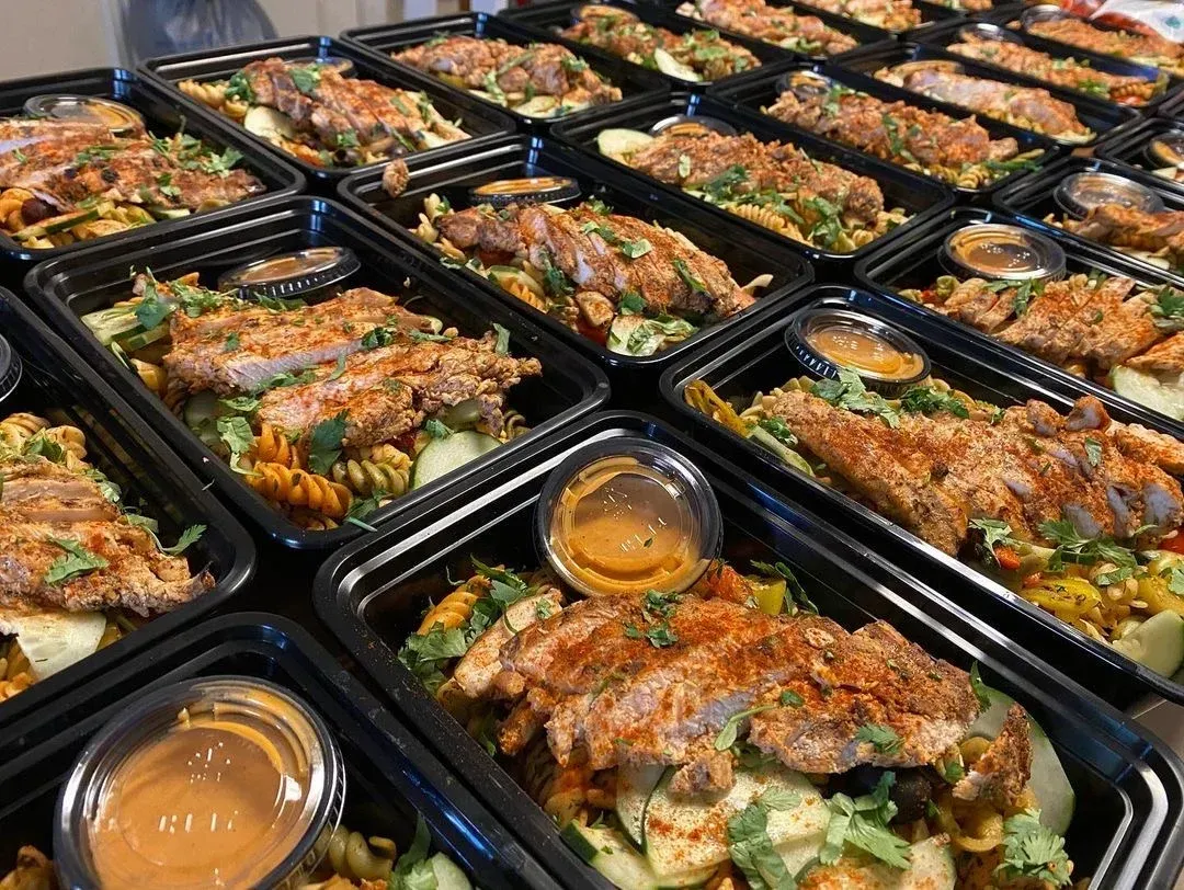 Prepared meal containers filled with pasta, chicken, and sauce.