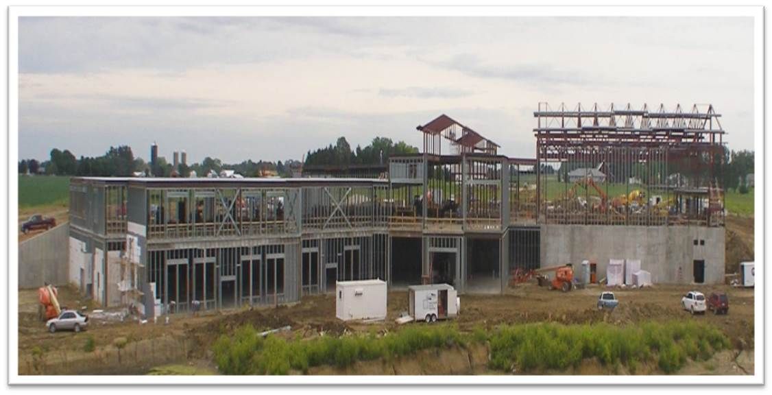 A large building is being built in the middle of a field