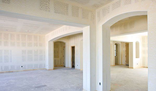 A large empty room with arches in a house under construction.