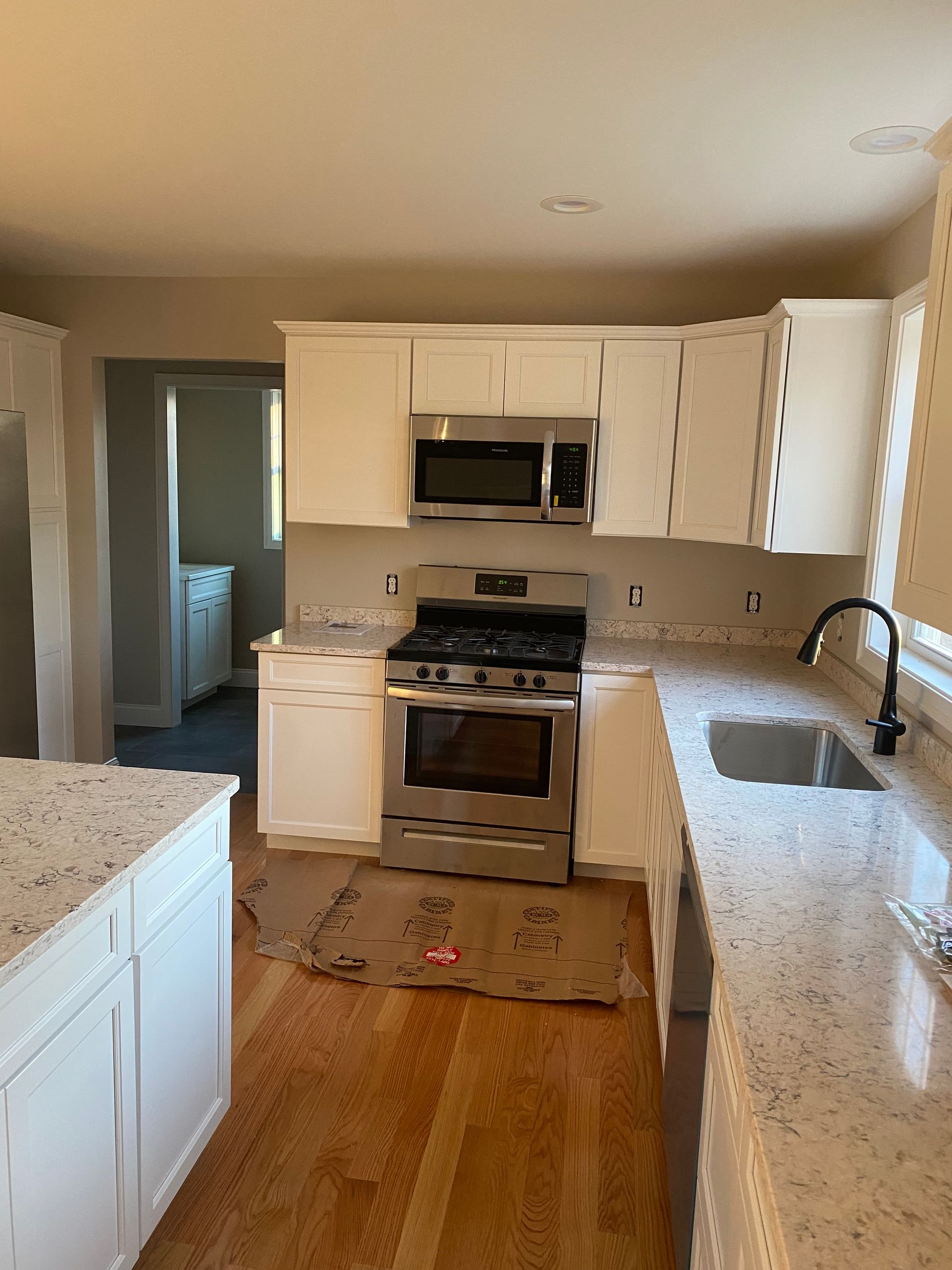 A kitchen with white cabinets and stainless steel appliances