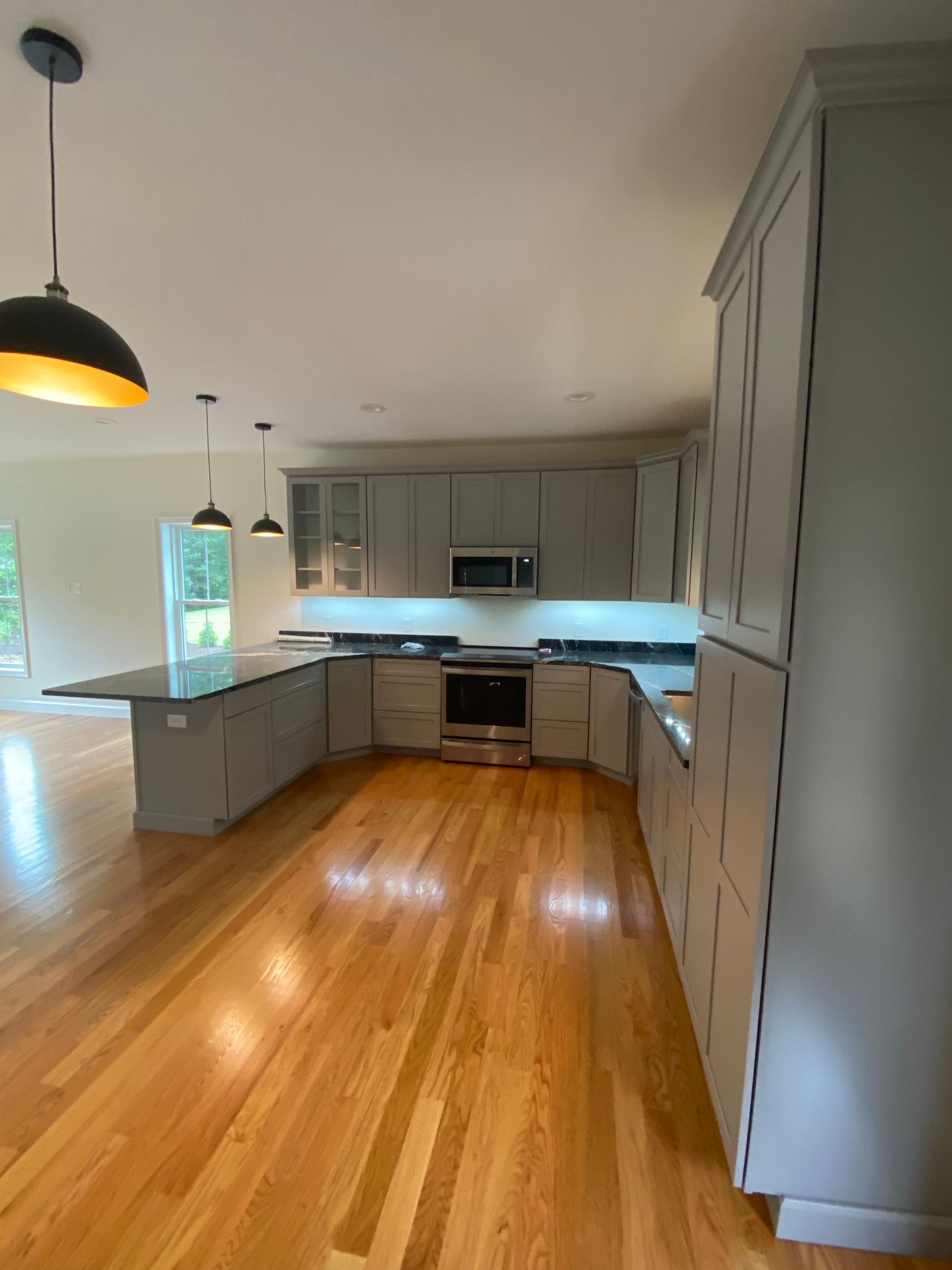 A kitchen with hardwood floors and white cabinets
