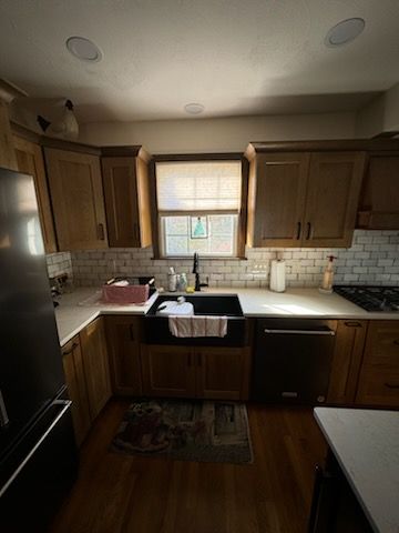 A kitchen with wooden cabinets, stainless steel appliances, a sink, and a window