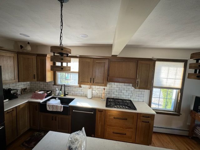 A kitchen with wooden cabinets and white counter tops