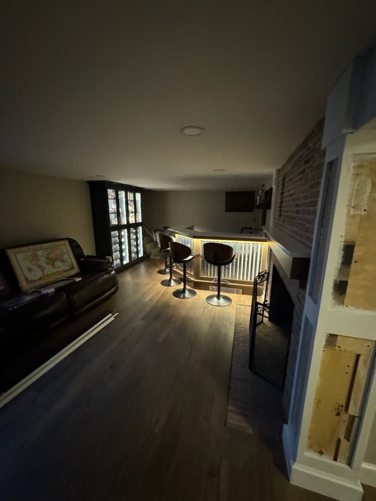 A living room with a bar and stools in it