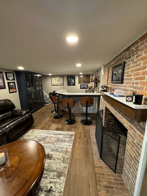 A living room with a fireplace and a brick wall