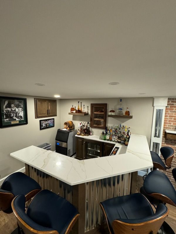 A kitchen with a bar and chairs and a refrigerator
