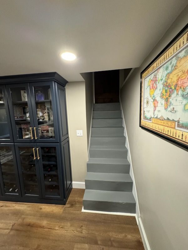 A staircase leading up to a basement with a map of the world on the wall