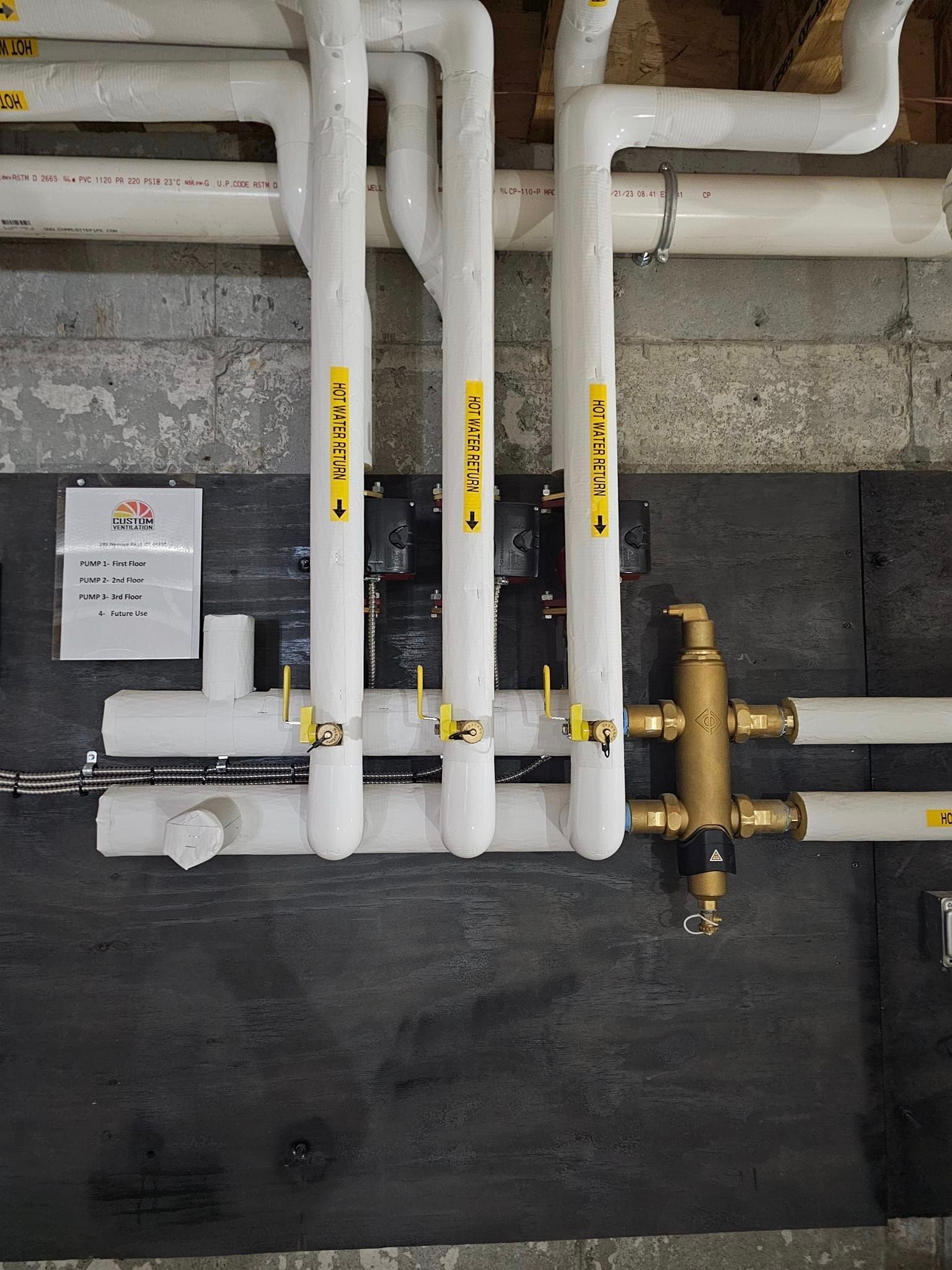 A bunch of white pipes with yellow labels on them