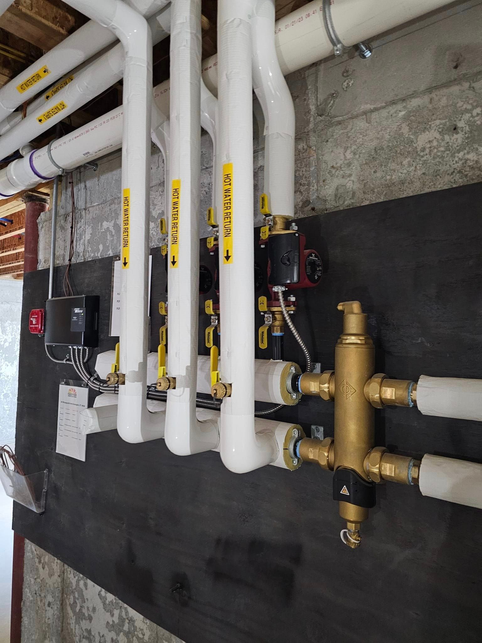 A bunch of pipes are connected to each other on a wall.