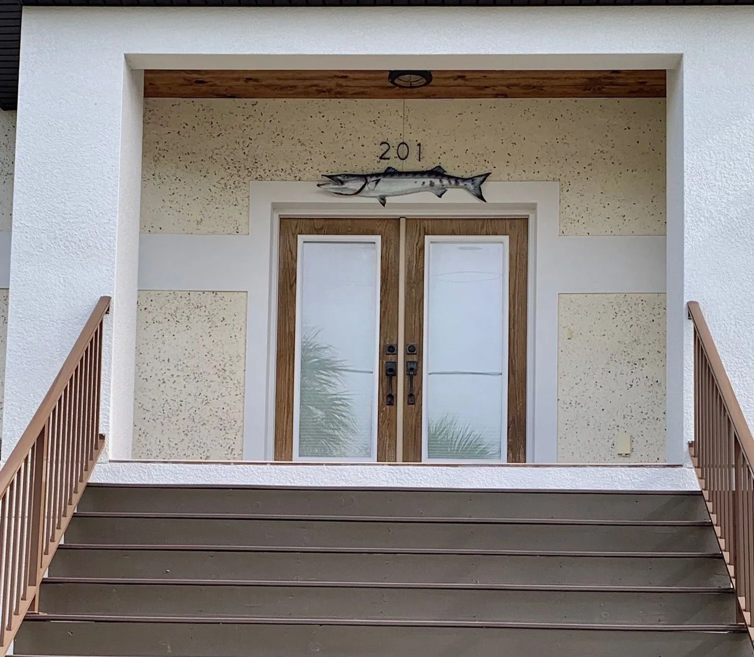 Stairs lead up to double doors with a fish decoration above; address 