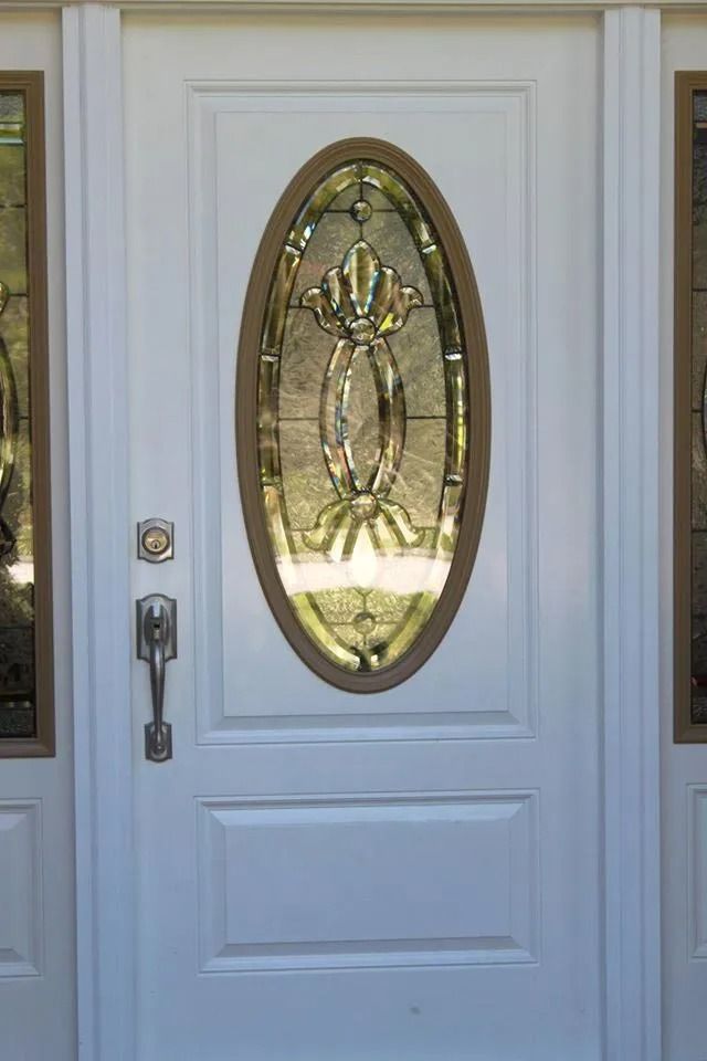 White front door with oval glass panel and sidelights.
