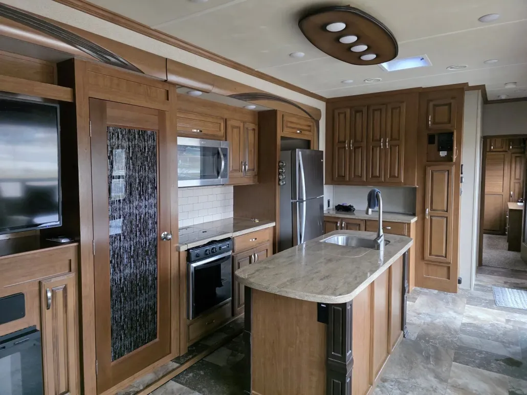 Modern kitchen interior with wood cabinets, stainless appliances, and a central island