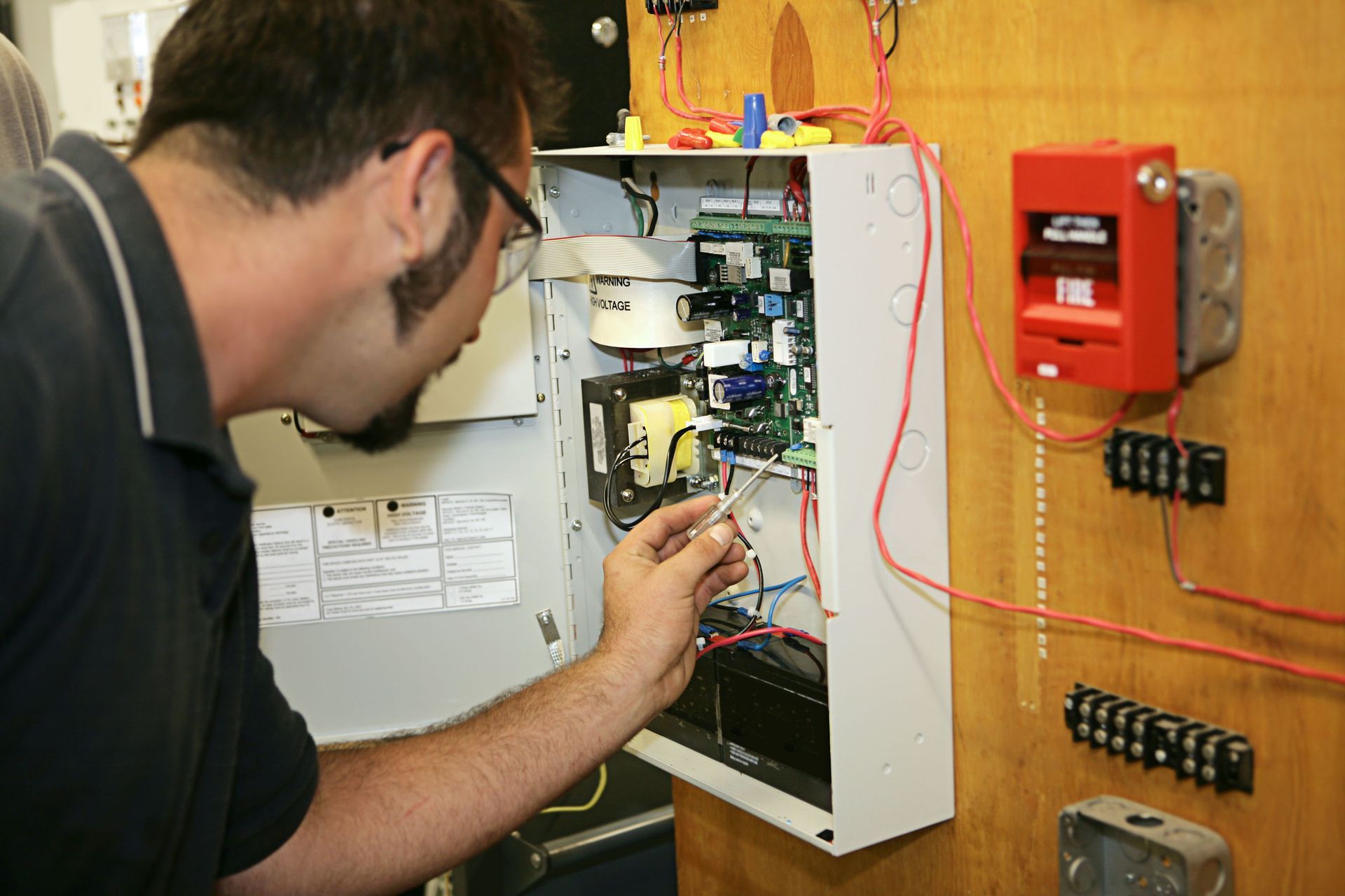 A man is working on a fire alarm system