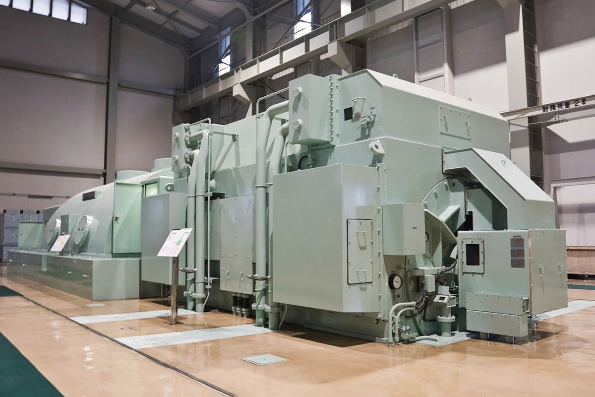 A large machine is sitting in a large room in a factory.