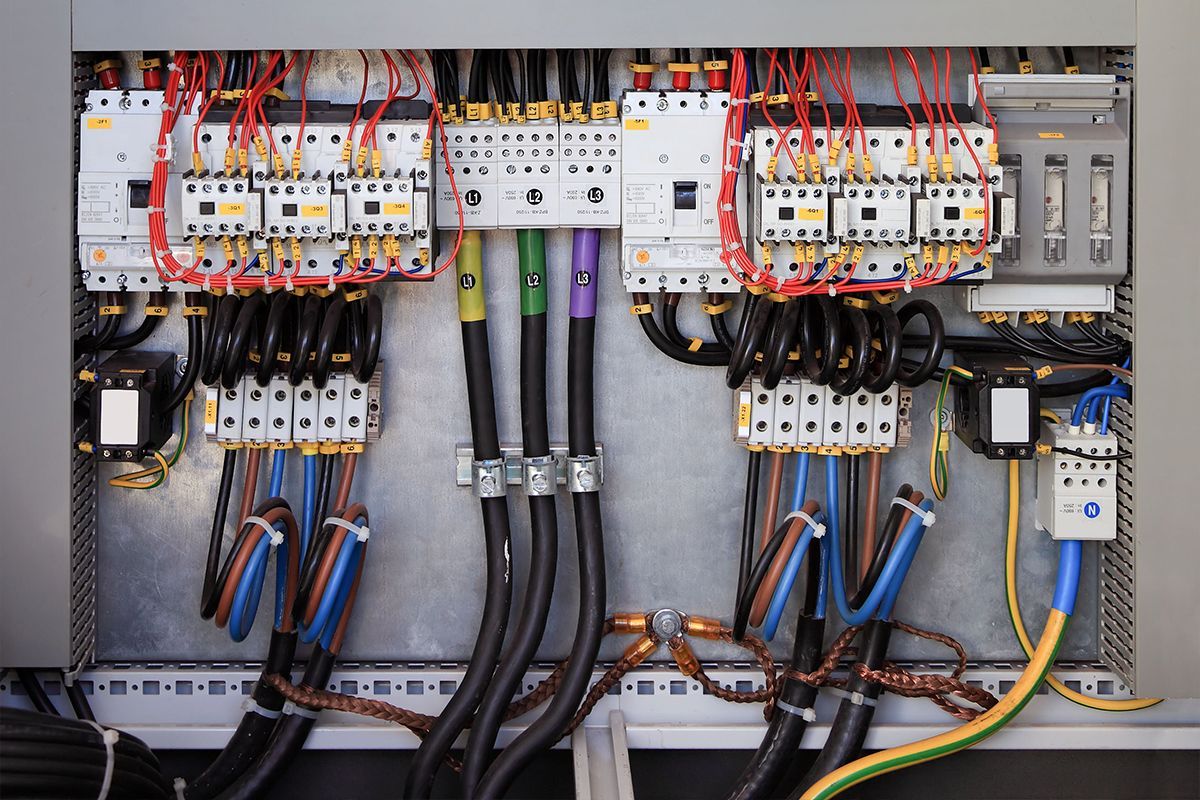 A man is installing a chandelier on the ceiling.