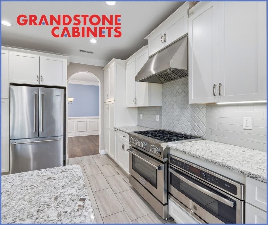 White kitchen with stainless steel appliances, granite countertops, and light tile floor.