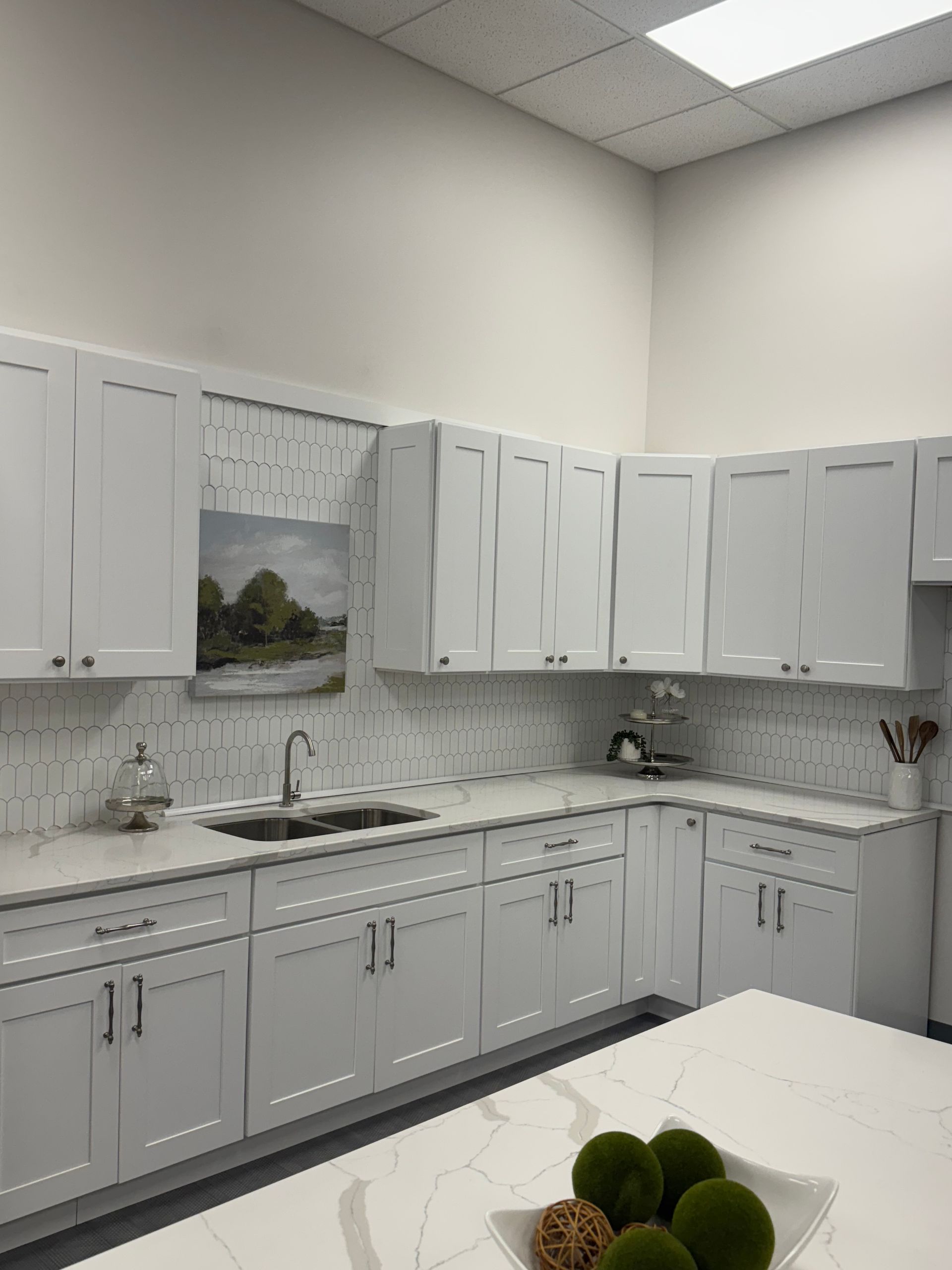 White kitchen with white cabinets, countertops, and a white backsplash.