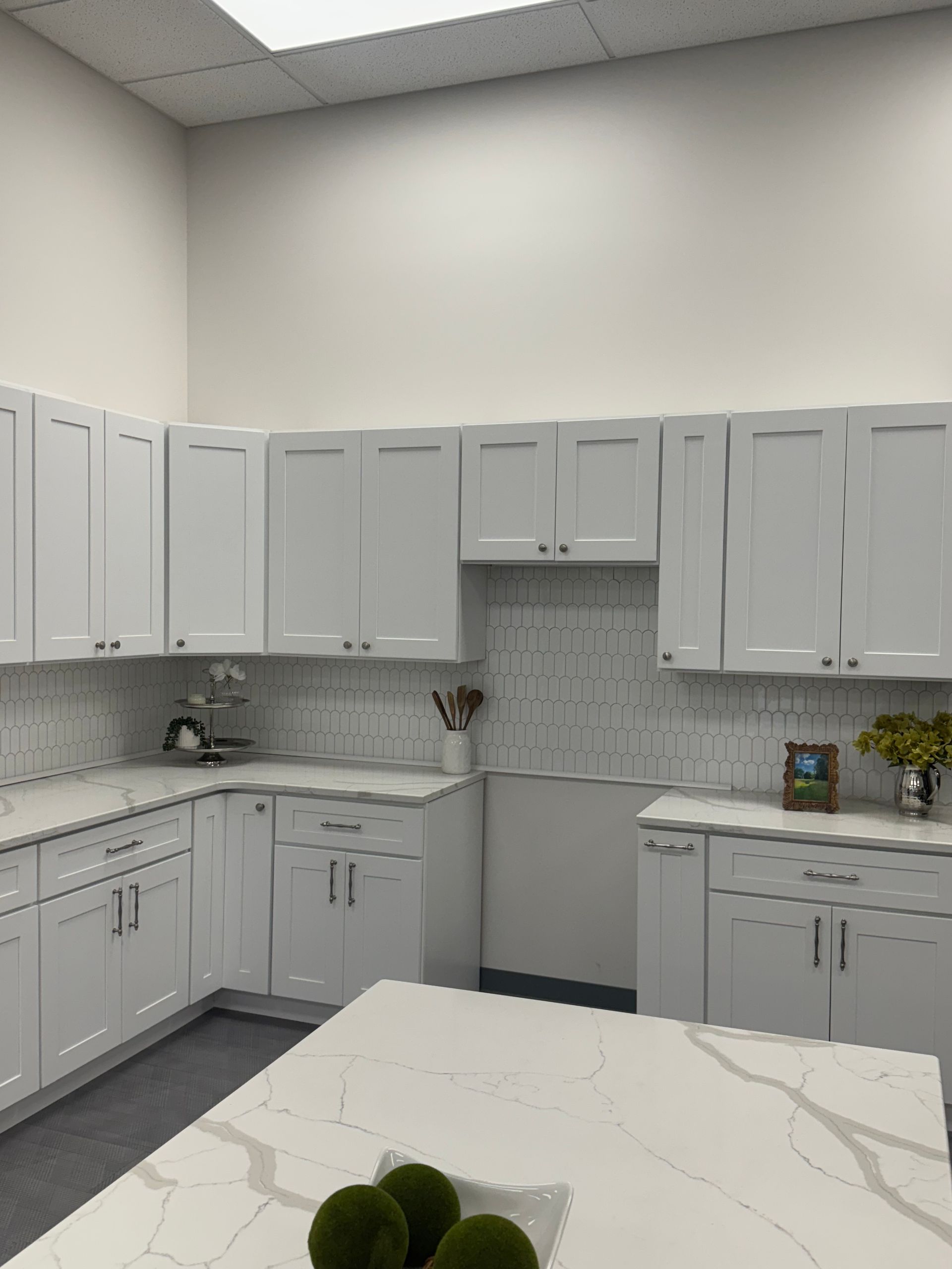 White kitchen cabinets with white countertops and backsplash.