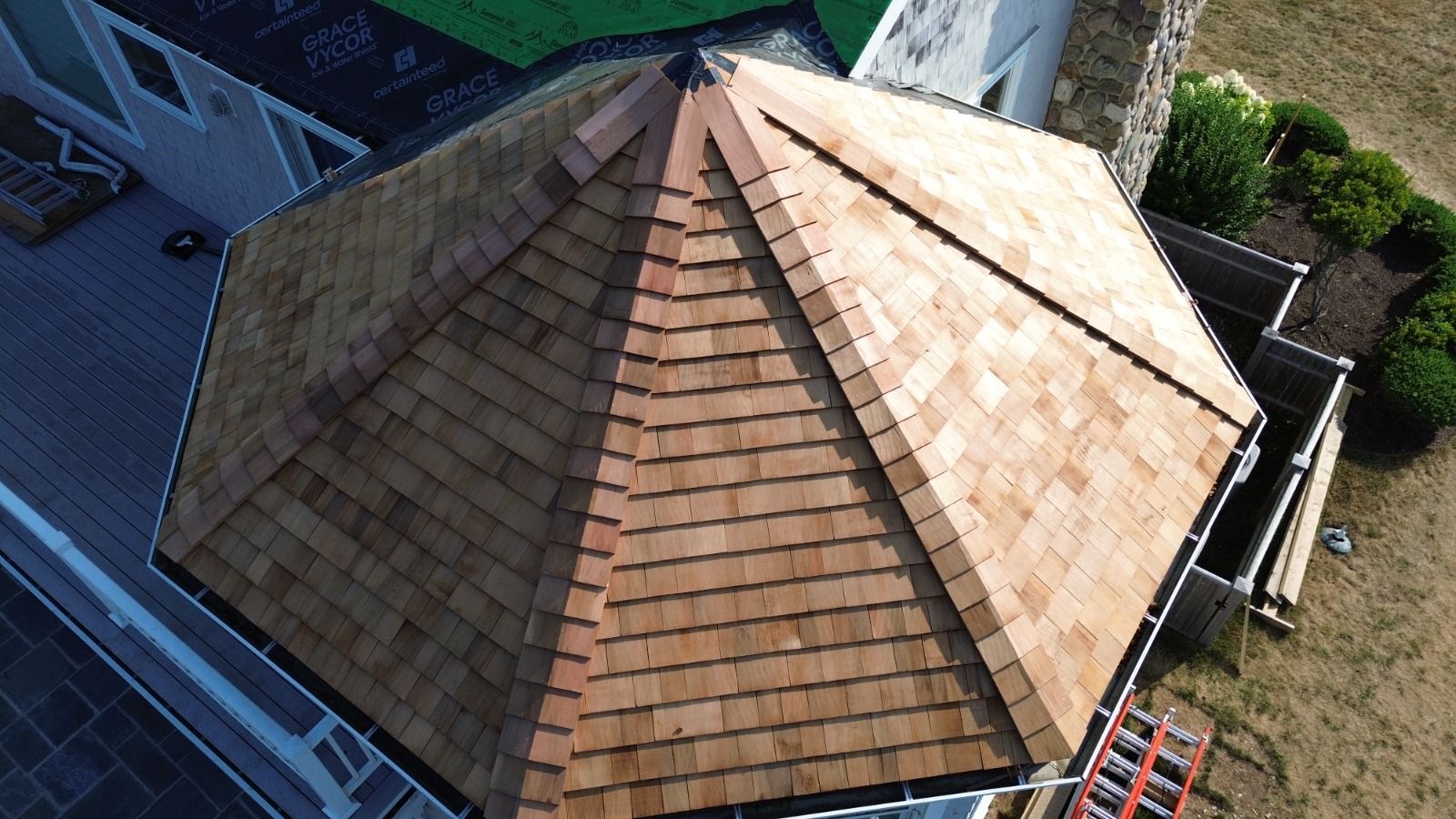 Overhead view of a wood shingle roof on a hexagonal structure.