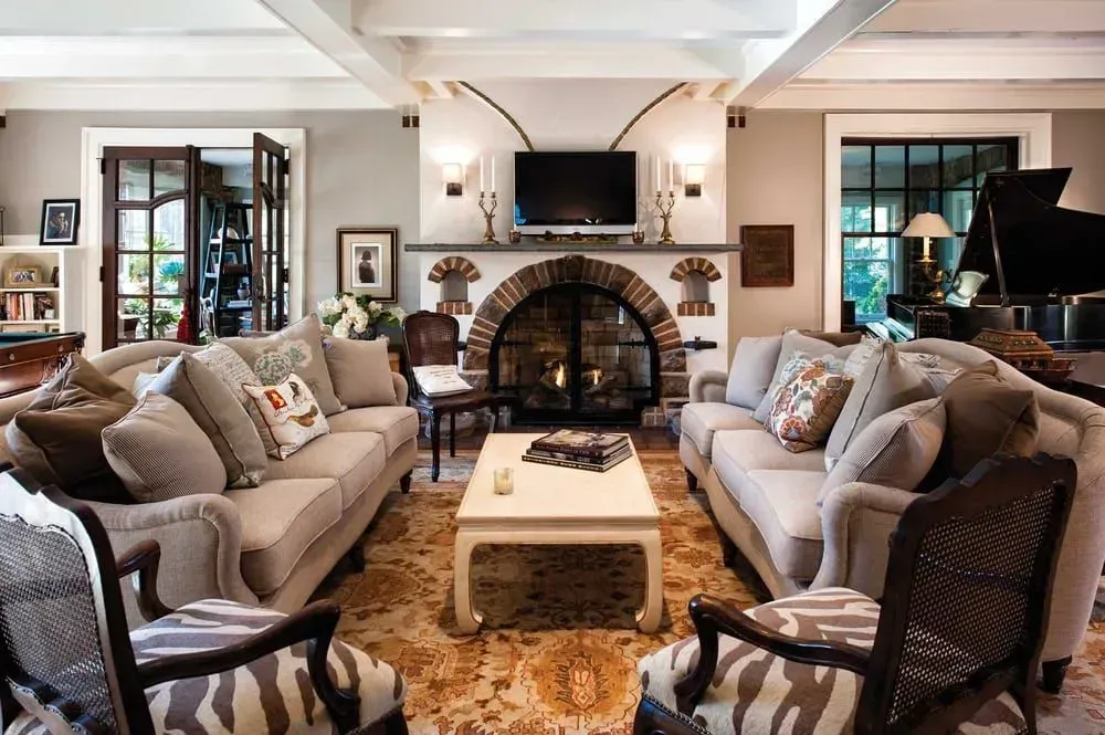 Living room with two sofas facing fireplace, rug, and a grand piano.