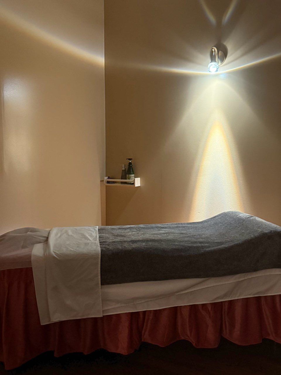 A bed in a room with a light shining on it.