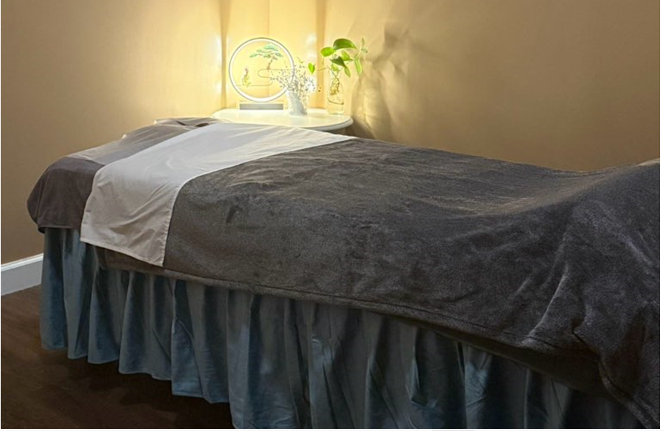 A bed with a blanket and a skirt in a room.