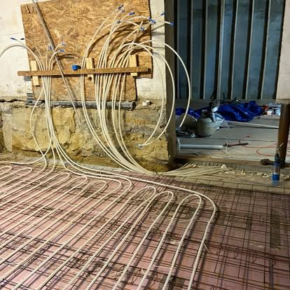 Construction site with coiled tubing, rebar mesh, and a partially built wall near a doorway